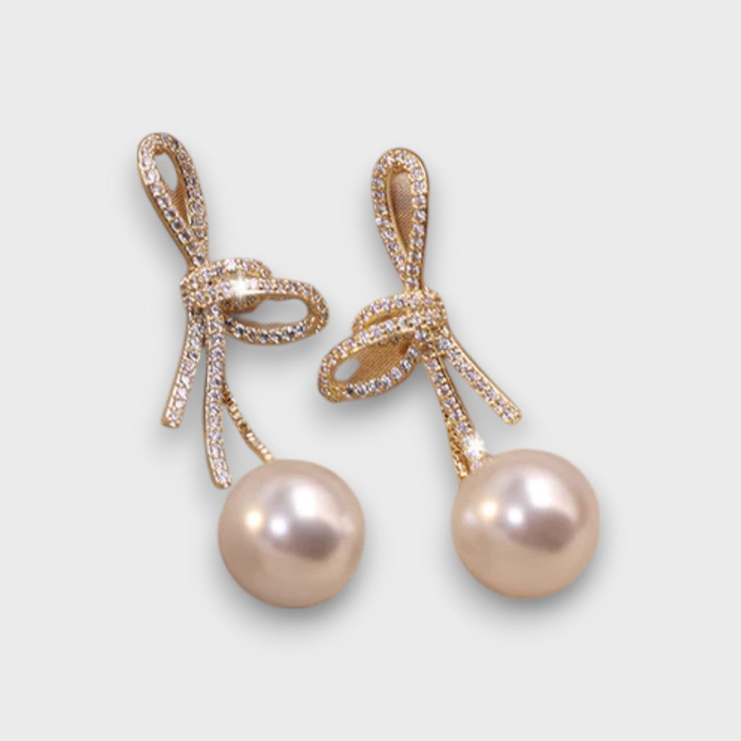 Celinea – Boucles d'oreilles en nœud doré avec perle lumineuse